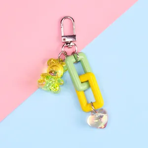Close-up of colorful bear keychain with yellow resin bear and translucent heart charm