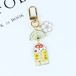 Détail d'un porte-clés de style japonais avec breloque chat porte-bonheur et éventail