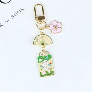 Détail d'un porte-clés japonais avec cerisier en fleurs éventail et charme de santé