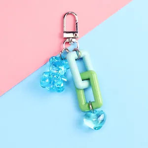 Detail of blue resin bear and heart pendant keychain with colorful plastic chain links