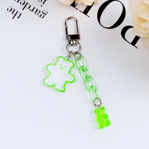 Detail of green acrylic gummy bear keychain with glitter charms and metallic ring clasp