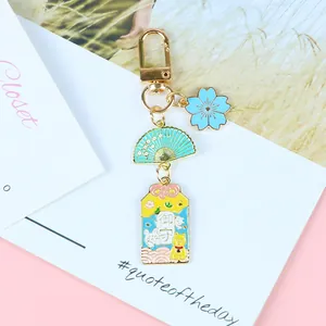 Détail d'un porte-clés porte-bonheur japonais avec cerisier en émail et pendentif Shiba Inu