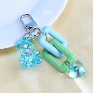Detail of blue resin bear keychain with interlocking pastel links and heart charm