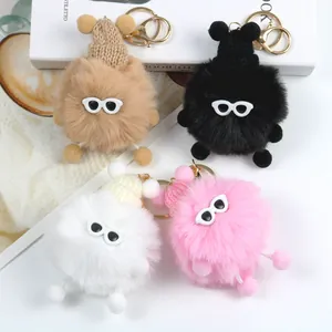 Dettaglio di quattro portachiavi mostri di peluche con occhiali da sole e cappelli