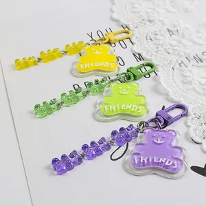 Three colorful acrylic bear keychains in yellow, green, and purple with FRIENDS lettering