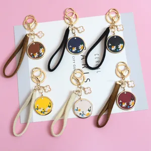 Detail of PU leather daisy embroidery keychains in six colors with gold carabiner