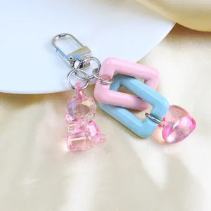 Detail of pink resin bear and heart charms with interlocking chain links on silver clasp