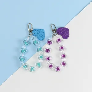 Detail view of blue and purple beaded heart keychains with silver metal clasps