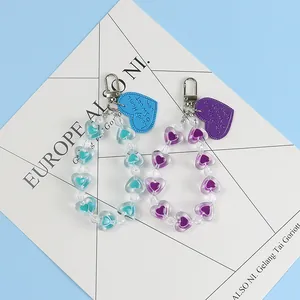 Detail of colorful beaded heart keychains in blue and purple with silver metal clasps