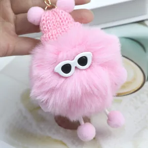 Dettaglio portachiavi mostro di peluche rosa con berretto, occhiali e gancio dorato