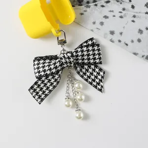 Yellow earphone case with houndstooth ribbon bow and pearl diamond pendant