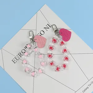 Macro view of beaded heart keychains with engraved pink and red heart-shaped tags