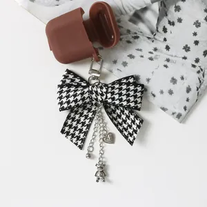 Brown silicone headphone case with a stylish houndstooth bow and bear charm pendant