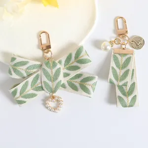 Creative pearl bracelet keychain with embroidered leaf ribbon and heart-shaped pendant