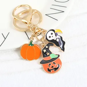 Detail of Halloween keychain with enamel grim reaper and pumpkin charms on a plate
