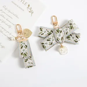 Vintage pearl keychain with embroidered floral ribbon and shell charms for handbags