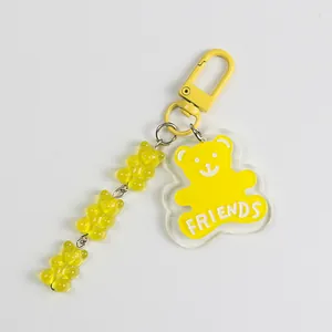 Macro detail of yellow acrylic bear charm with FRIENDS text and resin gummy bear beads