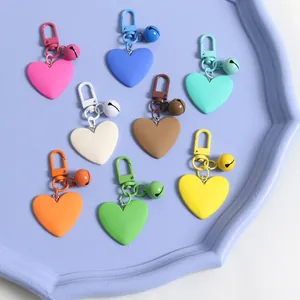 Close-up of heart-shaped keychains with matching bells in various macaron colors