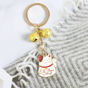 Détail d'un porte-clés chat porte-bonheur avec cloches dorées et pendentif Maneki-neko