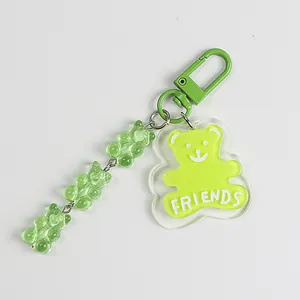 Detail of light green bear keychain with resin beads and Friends acrylic pendant