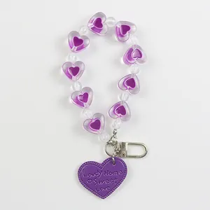 Detail of purple heart beaded keychain with Lovely Home Sweet Love engraved tag