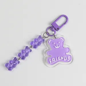 Detail of purple transparent acrylic bear keychain with white FRIENDS text and metal clasp