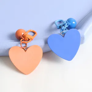 Macro shot of orange and blue heart-shaped keychains with matte lobster clasps