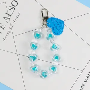 Macro view of blue heart beads and metal lobster clasp on a creative keychain