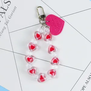 Macro view of pink heart-shaped beaded keychain with Lovely Home engraved tag