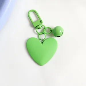 Close-up of heart-shaped fruit green matte metal keychain with a bell and lobster clasp