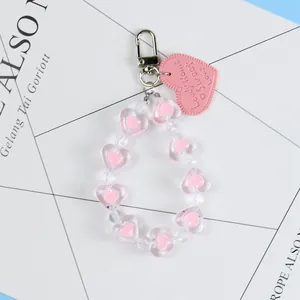 Close-up of pink heart beaded keychain with Lovely Home engraved faux leather tag