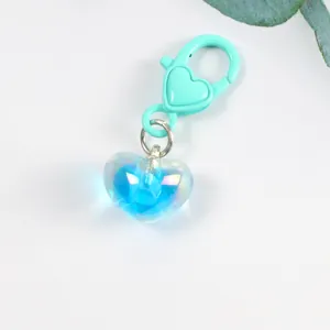 Close-up of translucent blue heart pendant with mint green lobster clasp on white background