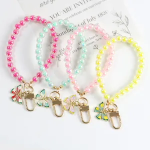 Detail showing four colorful acrylic butterfly beaded keychains with gold metal clasps