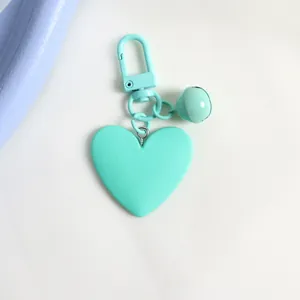 Detailed view of mint green heart-shaped keychain with matching bell and matte finish