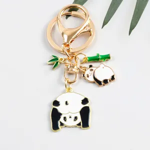 Dettaglio portachiavi panda dorato con foglie di bambù e ciondoli per borsa