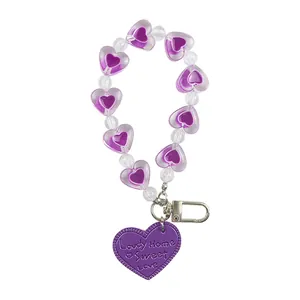 Creative purple heart-shaped beaded keychain with metallic D-ring buckle on white background