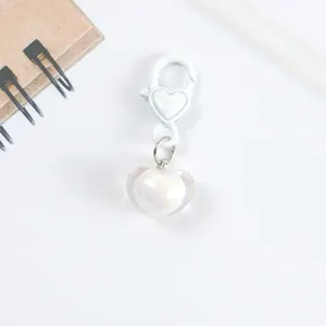 Close-up of heart-shaped keychain with iridescent acrylic pendant and white lobster clasp