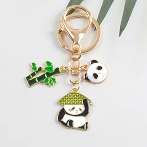 Dettaglio del portachiavi a forma di panda dorato con ciondolo di bambù per borse