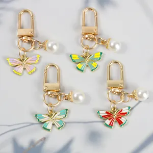 Detail of colorful enamel butterfly keychains with white pearls and gold clasps