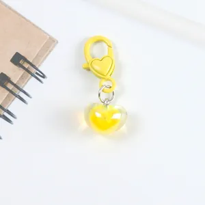 Macro detail of bright yellow heart pendant with matching decorative lobster clasp