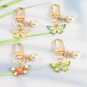 Detail of four colorful butterfly charms with lobster clasps and white pearls