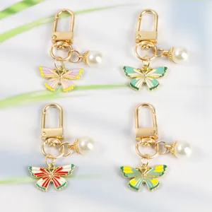 Detailed close-up of colorful enamel butterfly pendants with white faux pearls and gold clips