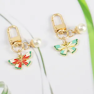 Close-up of golden butterfly pendant with pearls and colorful enamel details