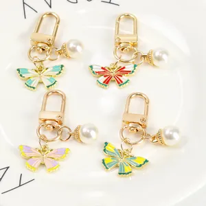 Detailed view of four colorful butterfly pendants with pearls and golden metal alloy clasps