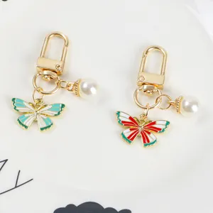 Detail of colorful enamel butterfly pendants with white faux pearls and gold lobster clasps