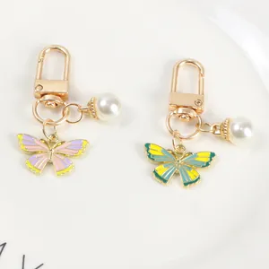 Detail view of colorful enamel butterfly pendants with golden hooks and small pearls