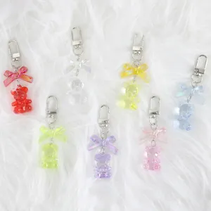 Colorful resin bear keychains with iridescent bows in seven colors on plush background