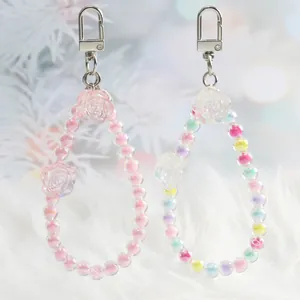 Macro view of colorful crystal flower bead charms with pink teardrop resin and silver clasps