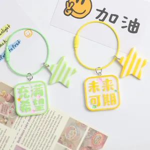 Detail of square acrylic charms with stars on yellow and green wire keychains