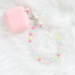 Close-up of pink silicone earbud case with colorful crystal flower beaded wristlet strap